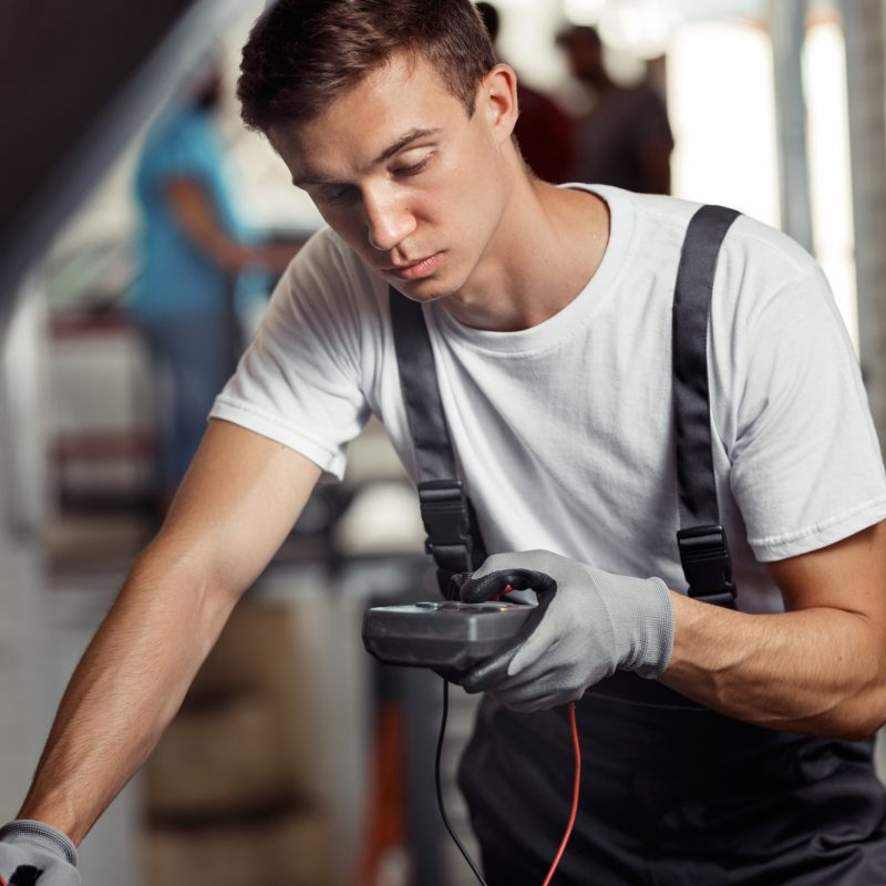 an-attractive-car-mechanic-is-checking-the-results-of-his-work-at-a-car-repair-service.jpg